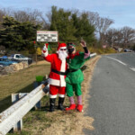 Santa and his elf by the side of the road